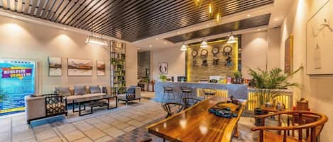 A modern interior with a wooden dining table, chairs, a bar area, and a seating area with sofas and a coffee table.
