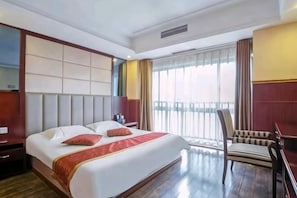 A hotel room with a large bed, a chair, a desk, and a window with curtains. - Chongqing Aisi Business Hotel (Chongqing)