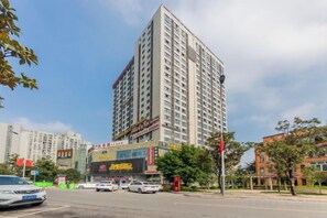 A multi-story building with a commercial ground floor, surrounded by trees and other buildings. - Chongqing Aisi Business Hotel (Chongqing)