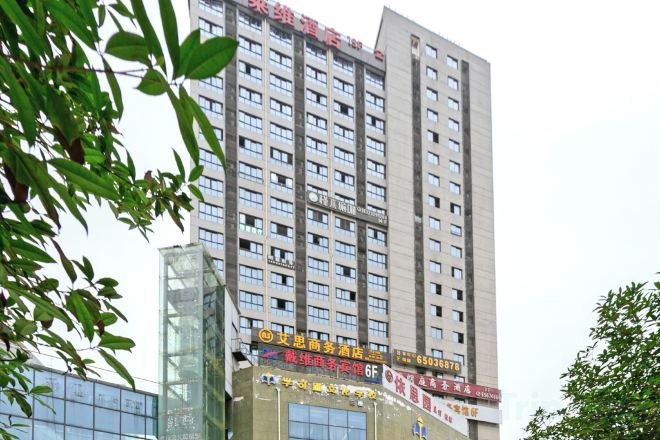 A high-rise building with multiple floors, large windows, and a prominent entrance with signage.