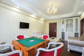 A room with a pool table, chairs, a television, and a chandelier. - Chongqing Aisi Business Hotel (Chongqing)