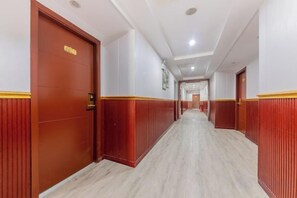 Een hotelgangen met houten deuren en een marmeren vloer.