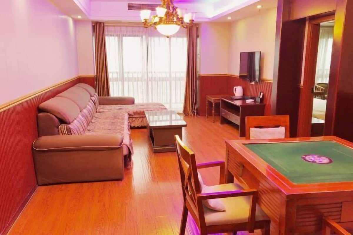 Une chambre d’hôtel équipée d’un canapé, d’une petite table, d’une télévision et d’une table de billard.