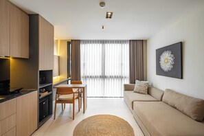 Appartement Deluxe, 1 très grand lit, vue piscine | Coin séjour | Télévision à écran plat