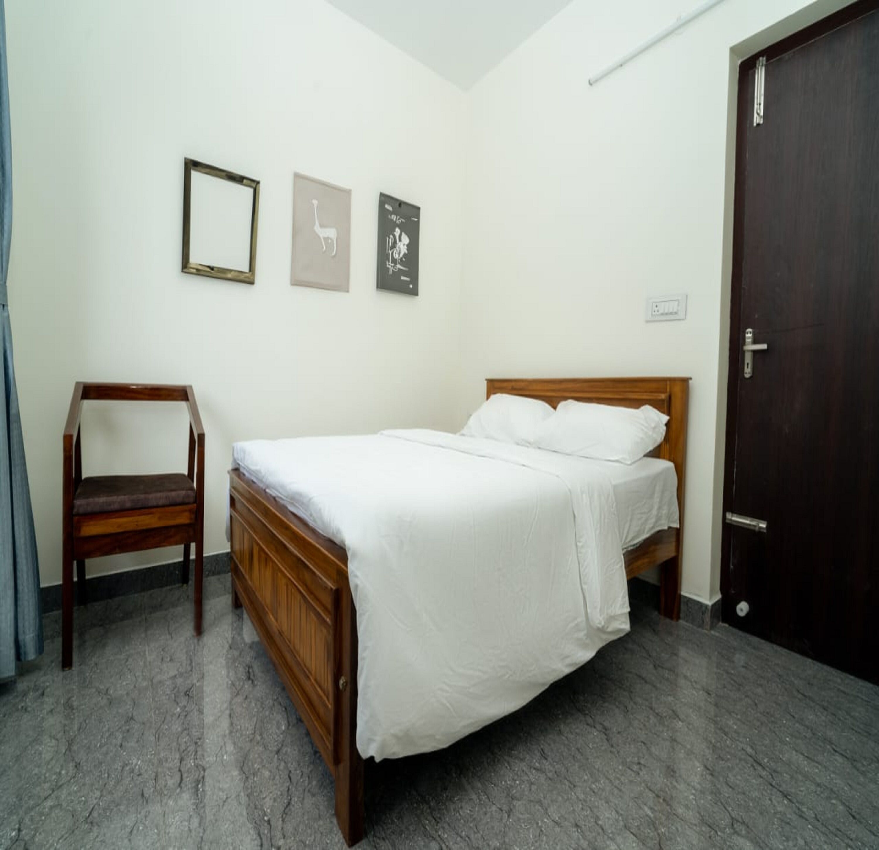 A bedroom with a wooden bed, a chair, and a door.