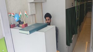 A hotel reception area with a desk, a globe, and flags. - Fathima Dormitory (Mumbai)