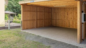 A wooden building with a sign reading 'FEWO EMILY' and a metal gate. - Cozy vacation apartment in the countryside, with sauna and garden (Garz)