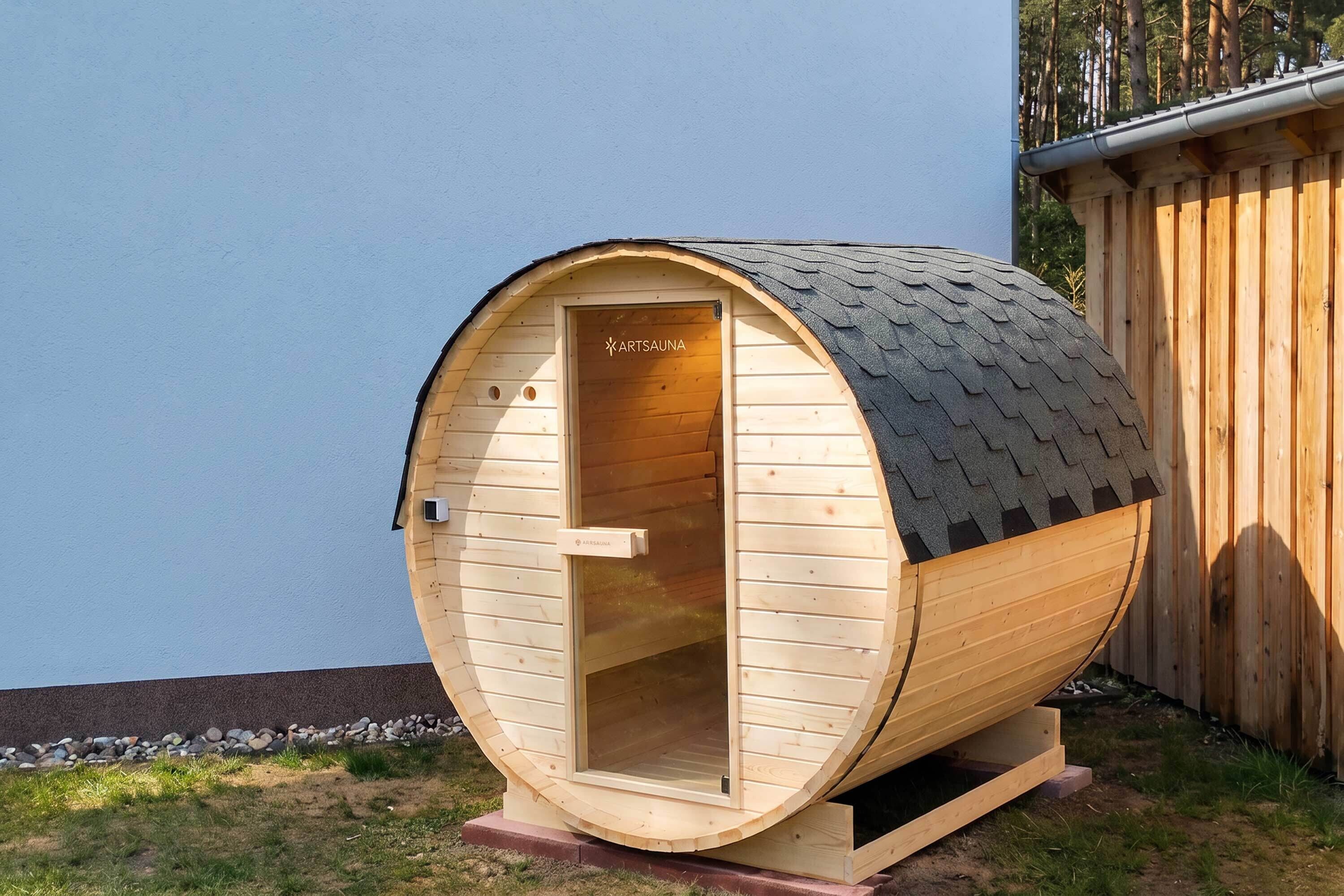Un sauna en bois doté d’un toit incliné et d’une porte portant l’inscription « ARTSAUNA ».