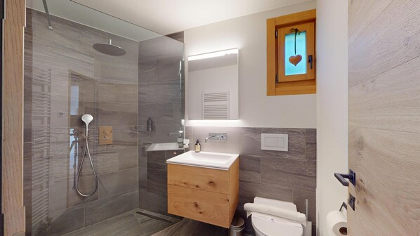 Une salle de bain moderne avec une douche à parois de verre, un meuble-lavabo en bois et des toilettes.