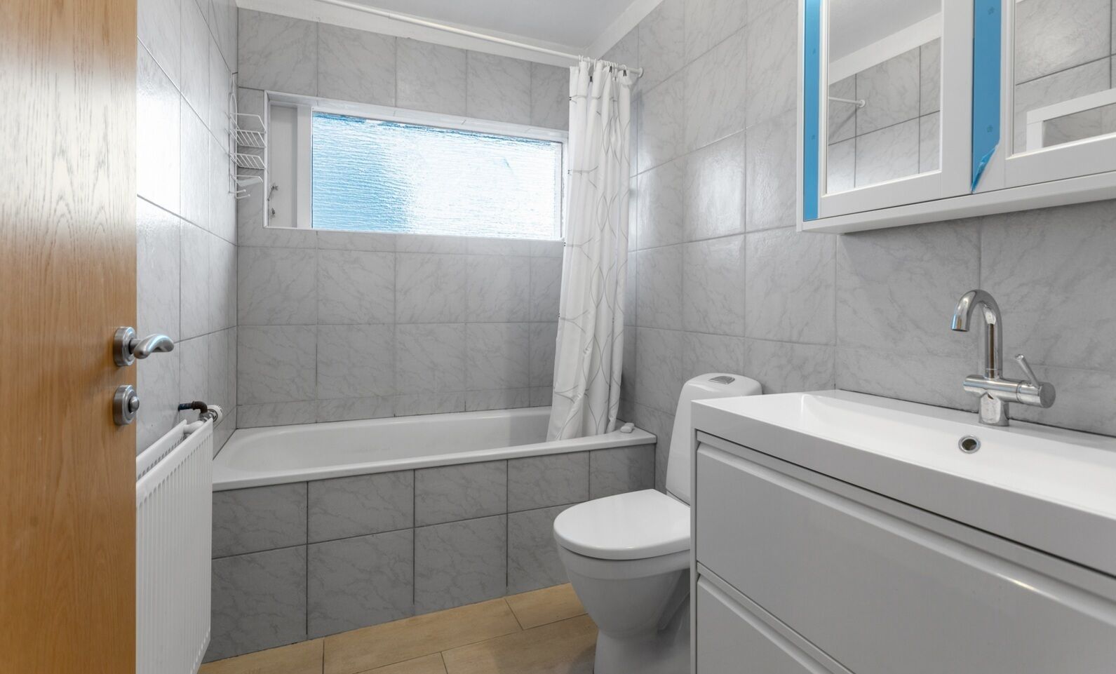 Une salle de bain avec une baignoire, des toilettes et une fenêtre.