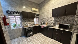 Una cocina moderna con armarios oscuros, estufa integrada y microondas.