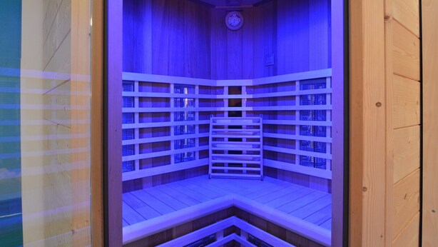 Eine Sauna mit Holzwänden und einer Uhr an der Decke.
