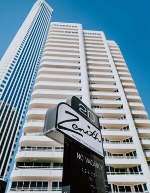 A hotel sign with the name 'Zenith' and 'Ocean Front Apartments' indicating no vacancies.