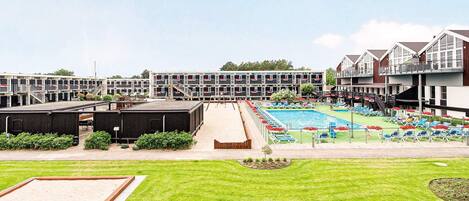 A hotel with multiple floors, a swimming pool, and outdoor seating areas.