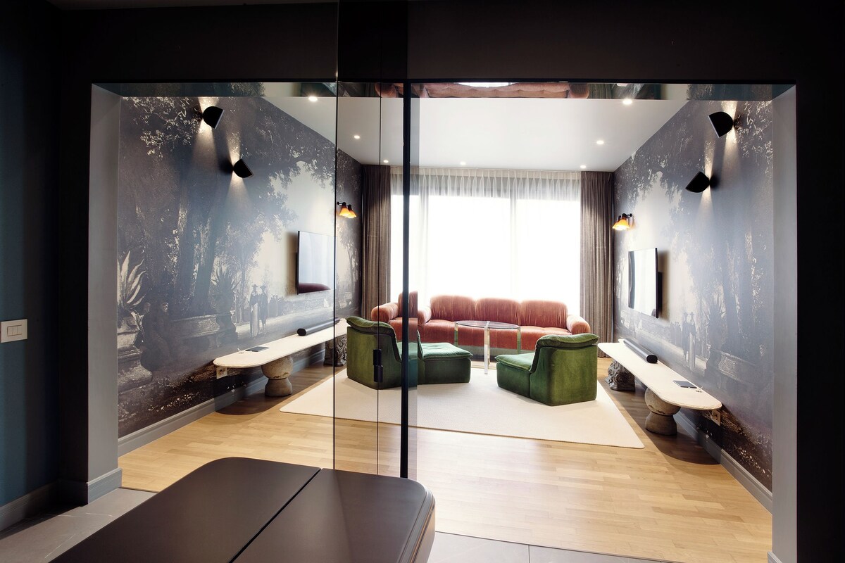 A modern living room with a sofa, green ottomans, a bench, and a large window with curtains.