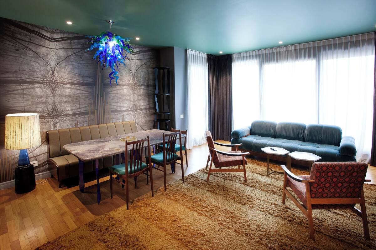 A modern living room with a dining table, sofa, and chairs.