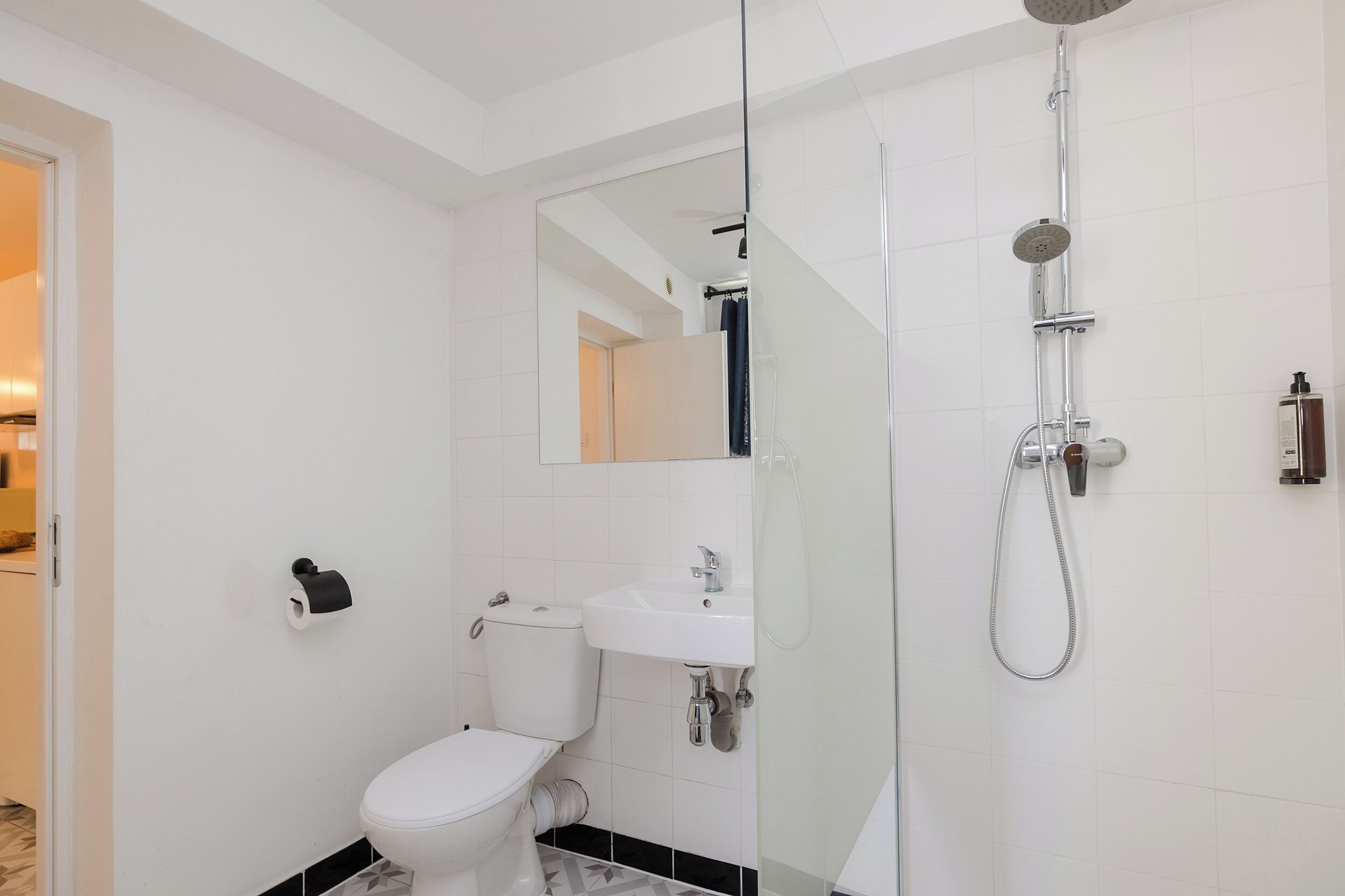 Ein modernes Badezimmer mit Toilette, Waschbecken und einer Duschkabine.