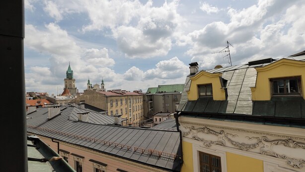 A view of a cityscape with various buildings, including a prominent tower with a green spire. - ShortStayPoland Krakowskie Przedmieście (Lublin)