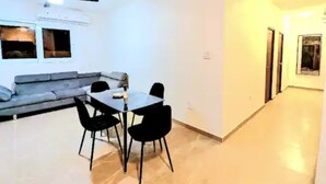 Un salon moderne avec un canapé, une table à manger et des chaises, ainsi qu’un ventilateur de plafond.