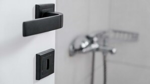 A modern bathroom with a black faucet and a wall-mounted control panel. - Orsiida Classic Double Room Volos (Volos)