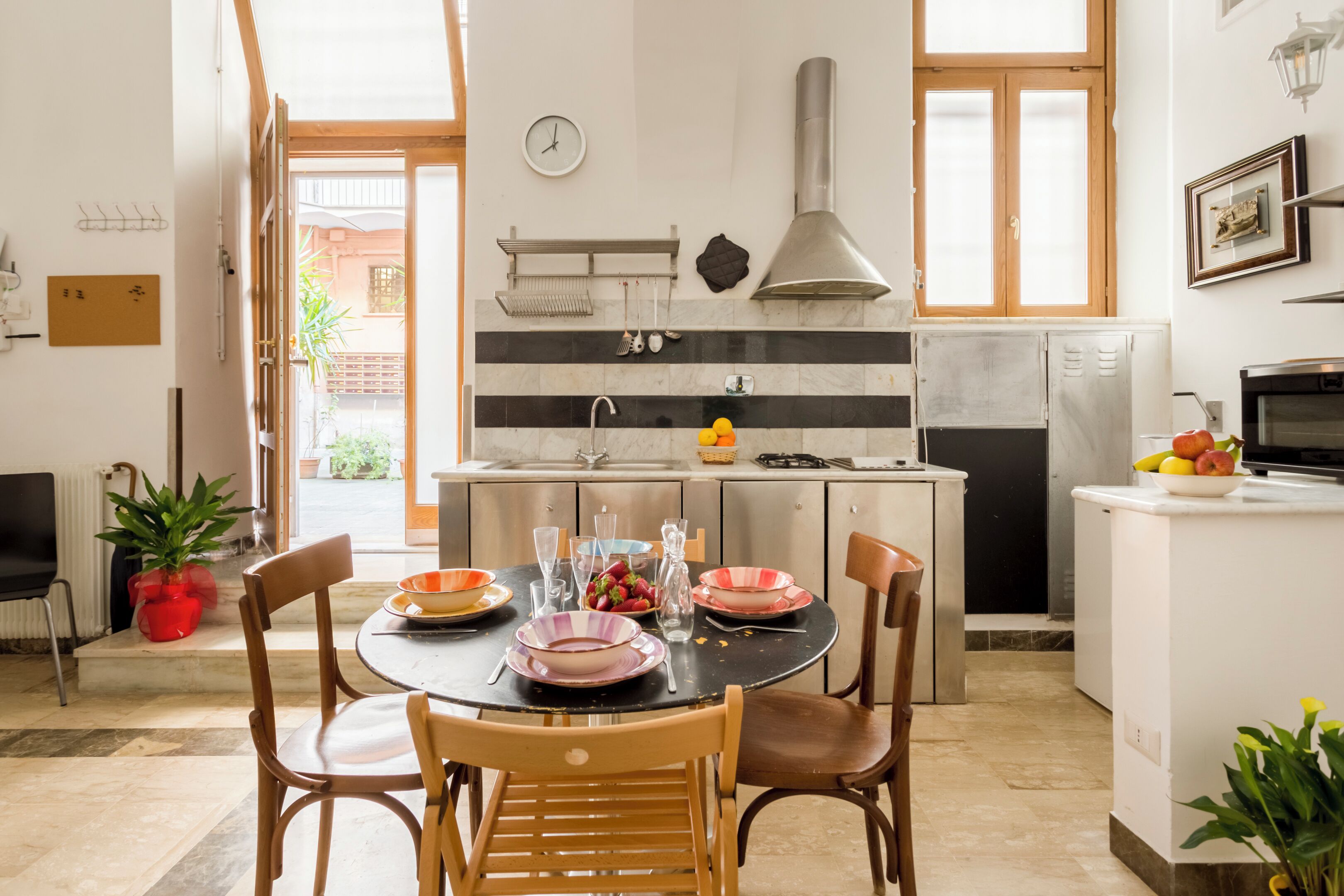 Une cuisine moderne avec un coin repas, comprenant une table ronde, des chaises et divers appareils de cuisine.
