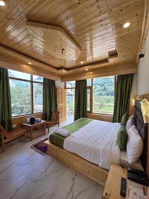A wooden-paneled bedroom with a large bed, green curtains, and a view of the outdoors. - Mb Igloo Resort (Manali)
