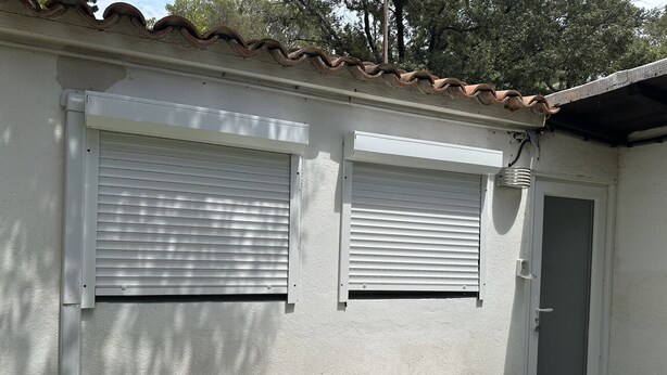 A small, single-room structure with two windows and a door, a white table, and a white chair. - 1 bedroom house 800m from the sea (Saint-Raphaël)