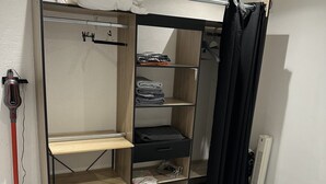 A compact bedroom with a bunk bed, a wardrobe with multiple shelves, a radiator, and a vacuum cleaner. - 1 bedroom house 800m from the sea (Saint-Raphaël)