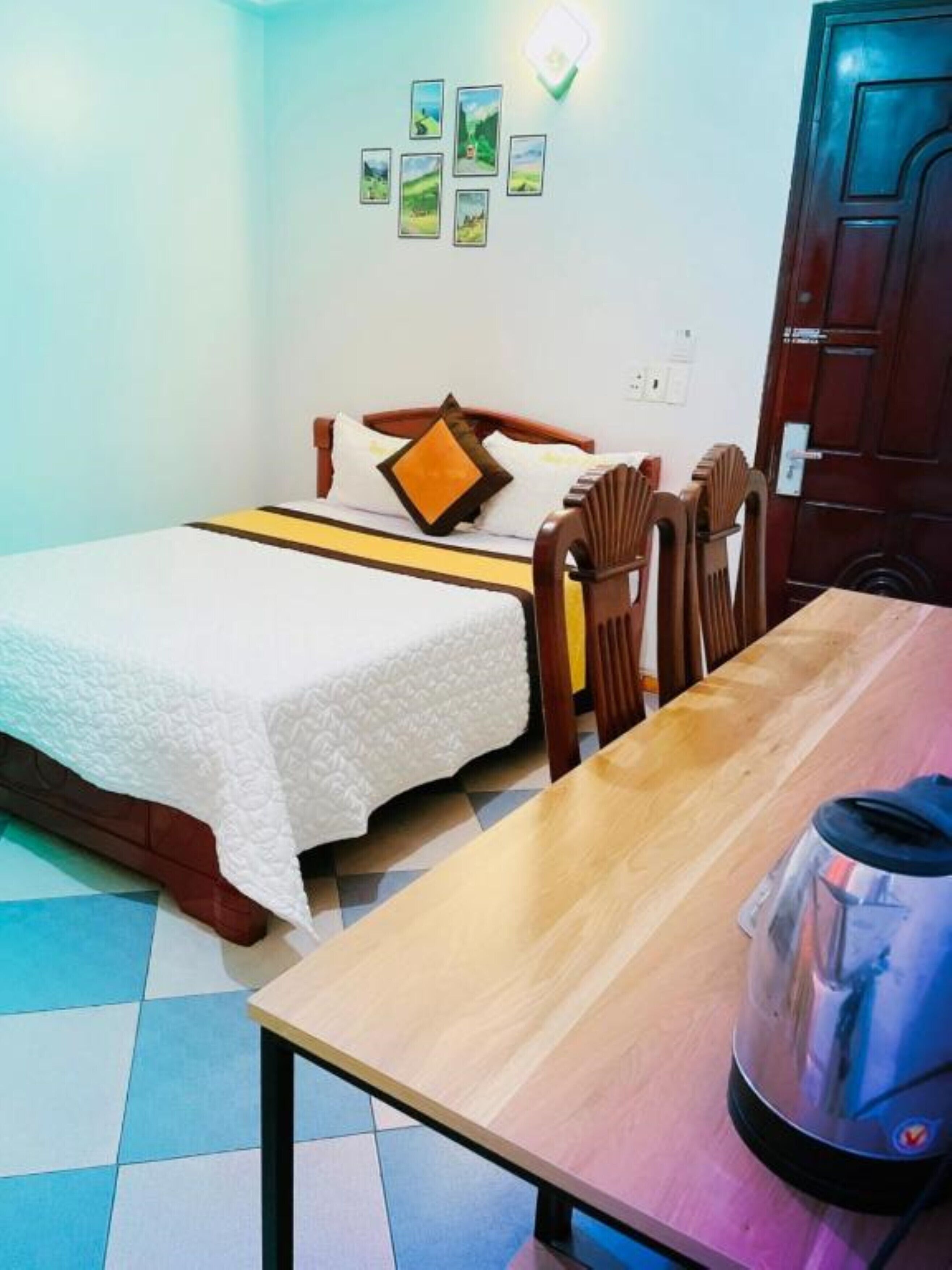 A room with a bed, a table, and a kettle.