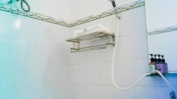 Casa de banho com sanita, lavatório, chuveiro e barra de toalhas.