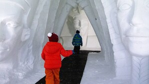 A corridor with a large statue of a woman, flanked by two figures, one in a red jacket and the other in a blue jacket. - Luxury 4* Chalet with Jacuzzi and Sauna (Vars)