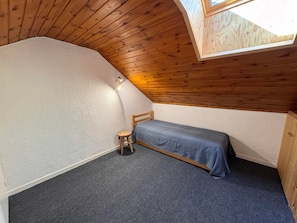 A small, sloped-roofed room with a single bed, a stool, and a skylight. - Apartment at the Slopes near ESF (Vars)