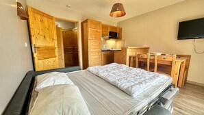 A bedroom with a bed, wooden wardrobe, and a small kitchenette. - Apartment Vars, 1 bedroom, 4 persons (Vars)