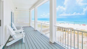 A covered porch with white railings and a view of a beach. - Orange Beach House East Beach Front, Private Pool, Sleeps up to 28, Quiet Beach! (Orange Beach)