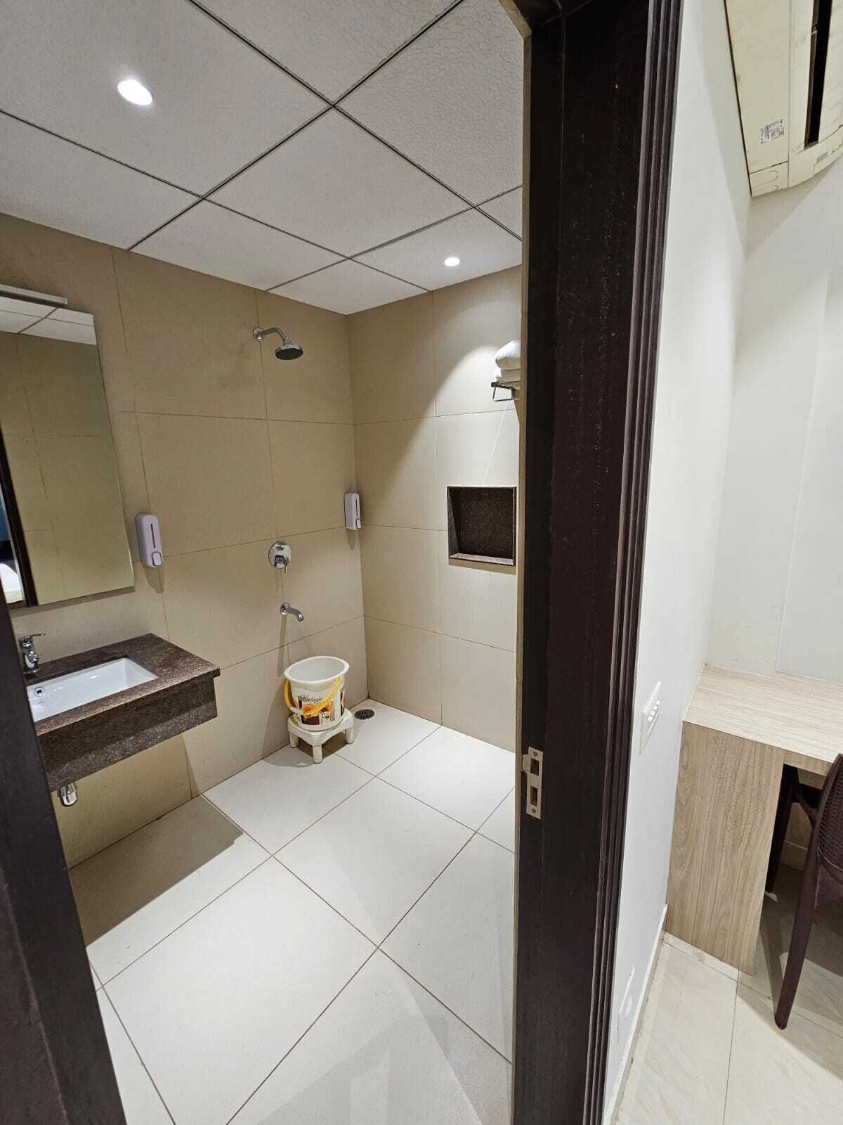 A modern bathroom with a sink, mirror, and shower.