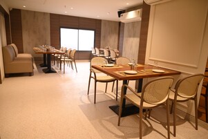 A conference room with a long table, multiple chairs, and a sofa.