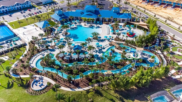 Eine Vogelperspektive zeigt ein Resort mit einem großen zentralen Pool, mehreren kleineren Pools und einem Wasserpark.
