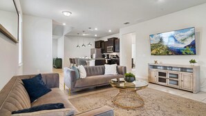 A modern living room with a sofa, coffee table, and a painting on the wall. - 2211 Lelani Circle (Davenport)