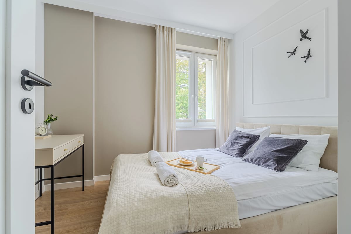 Ein Schlafzimmer mit Bett, Nachttisch und Fenster.