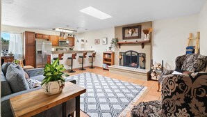 A modern living room with a fireplace, a dining area, and a kitchen. - Welcome to Casa de Ladrillos - No House guests without prior approval from host. (Albuquerque)