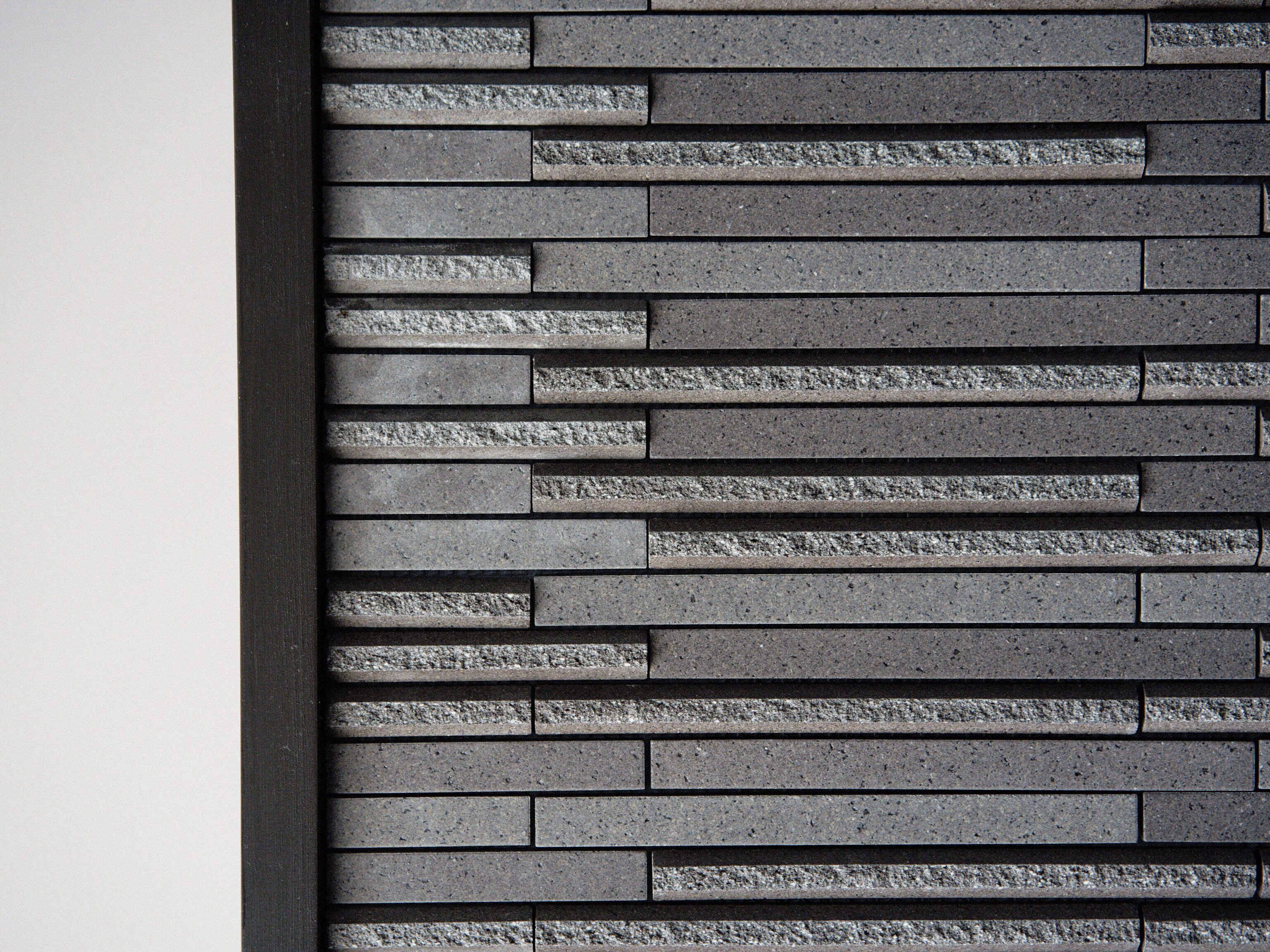 Un mur orné d’un motif composé de blocs de pierre rectangulaires.