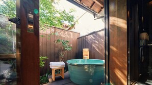 A wooden deck with a hot tub, a small stool with a towel, and a wooden fence. - Kyoto Machiya Kamogawa Gardens (Kyoto)