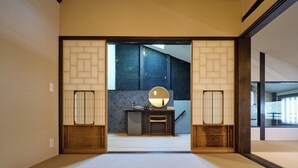 A traditional Japanese room with tatami flooring, a low wooden desk, and a large mirror. - Kyoto Machiya Kamogawa Gardens (Kyoto)