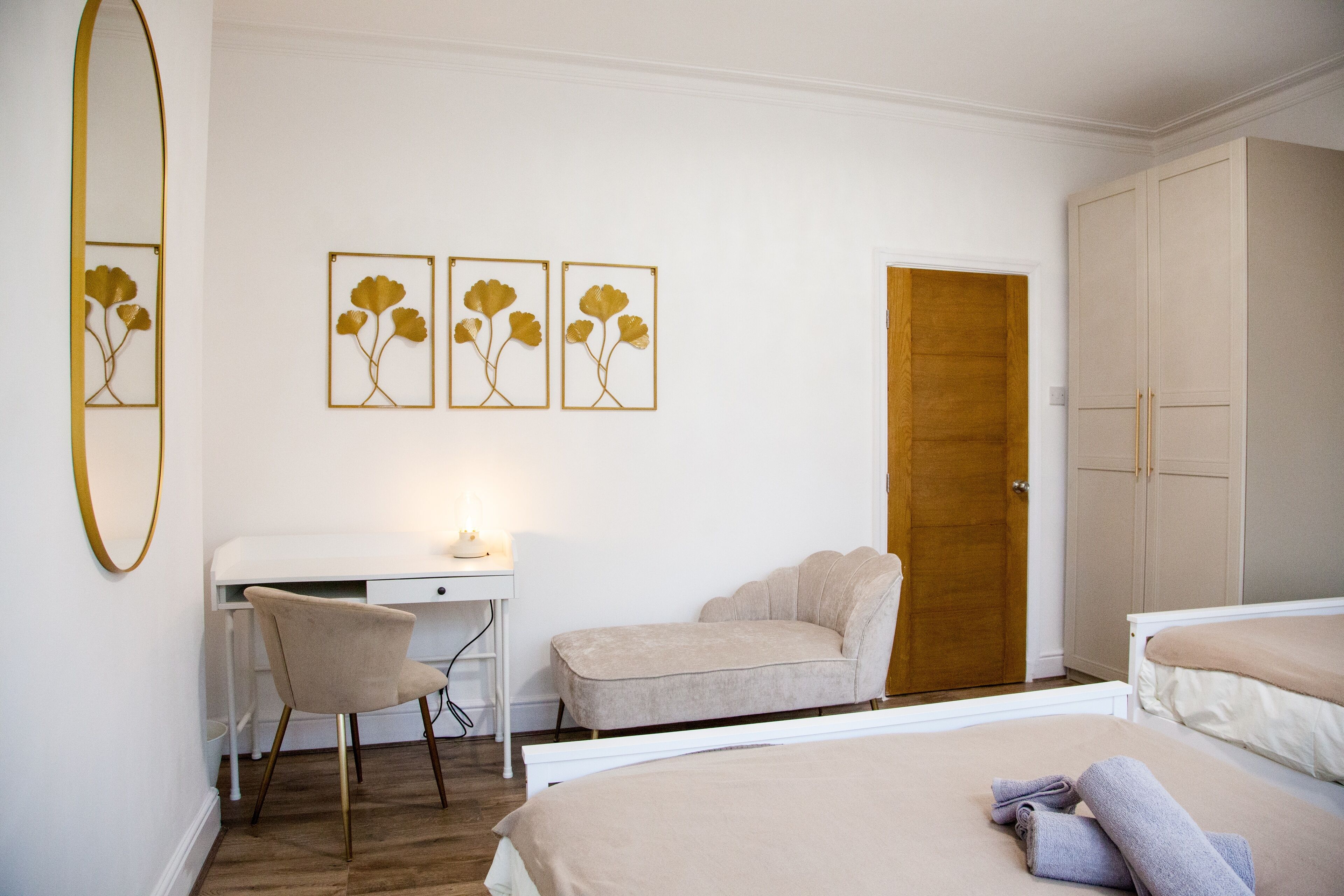 Ein Schlafzimmer mit Bett, Schreibtisch, Stuhl und Kleiderschrank.