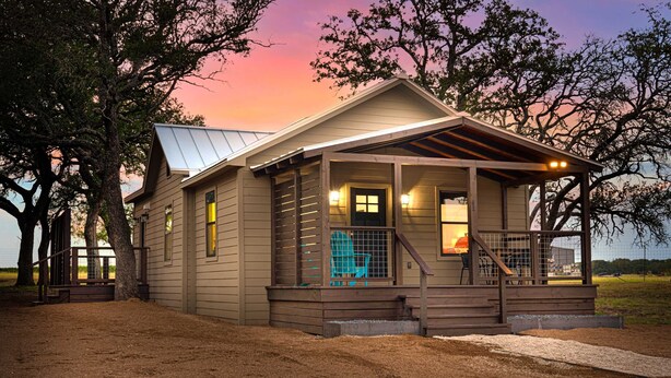 A house with a porch, a covered entryway, and a staircase leading to the door. - Starry Night Cottage 1 (Stonewall)