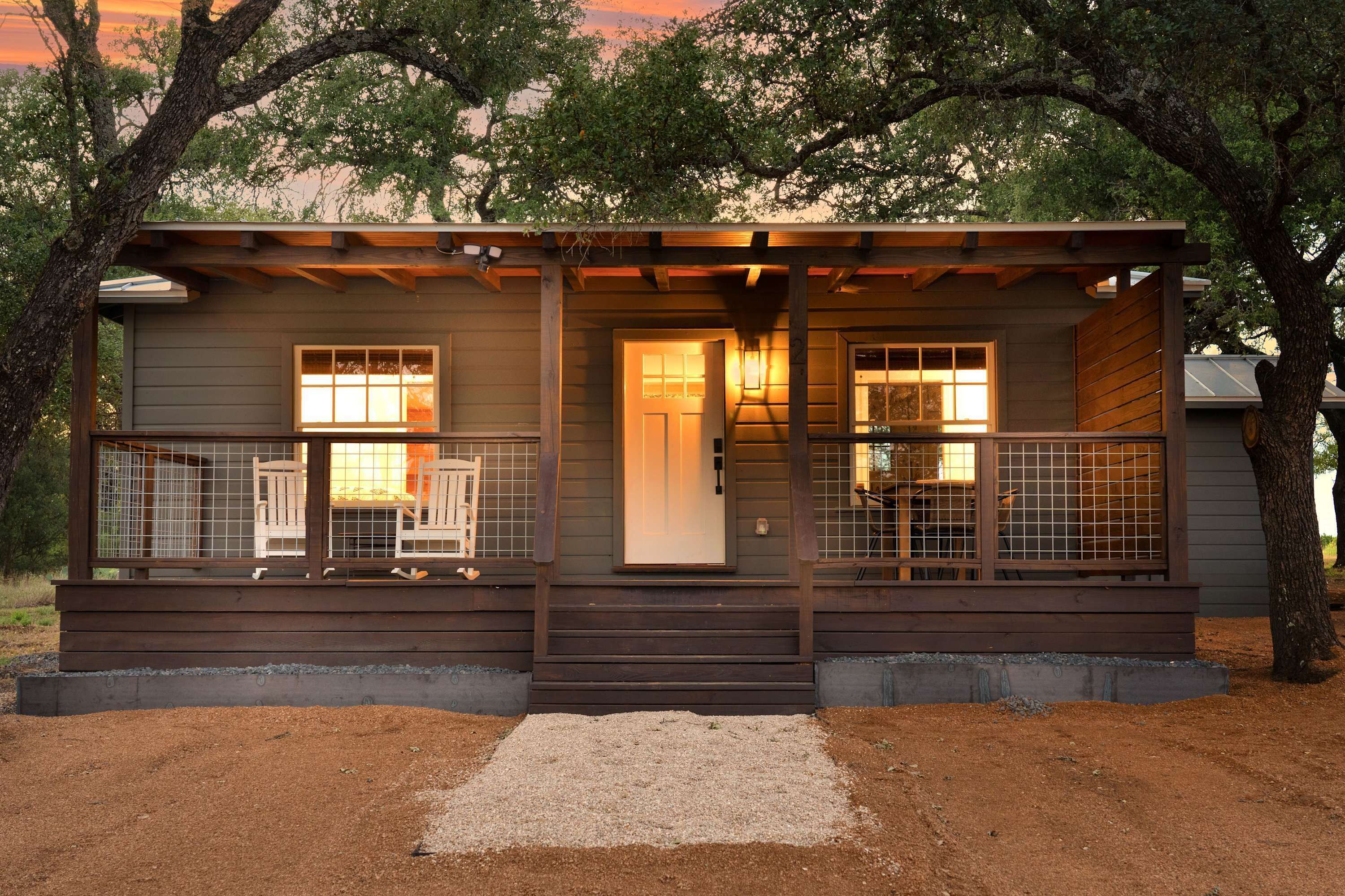 A cabin with a porch, a door, and a window.