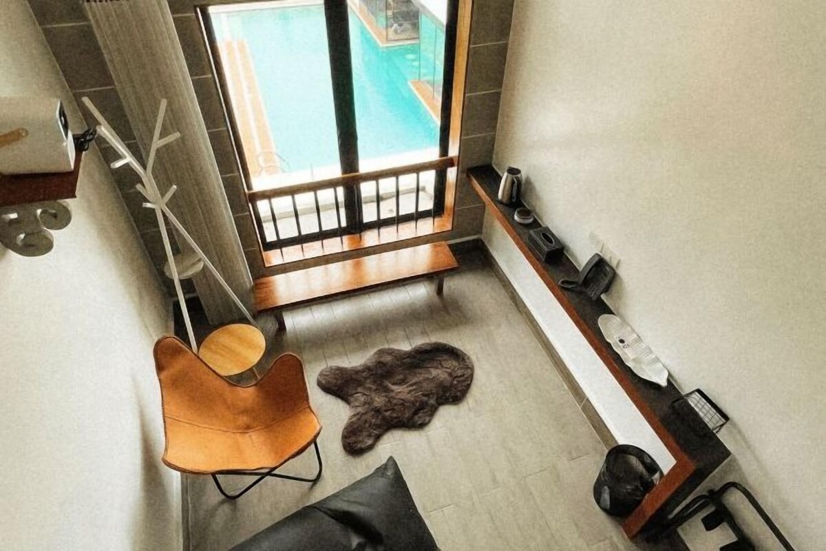 Une salle de bain moderne avec une grande fenêtre, un banc en bois, un tapis en fourrure et un porte-serviettes.