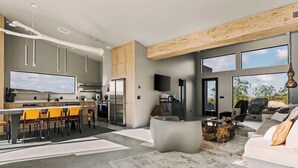 Una cocina moderna con barra, sillas de comedor y un ventanal grande.