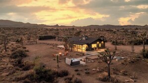 A desert-style house with a patio, outdoor seating, and a hot tub.