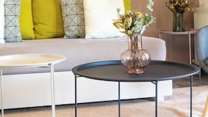A living room with a sofa, a coffee table, and two vases with flowers. - 4-bedroom villa in lovely Mili with AC, WiFi. Enjoy a relaxing stay (MILI)